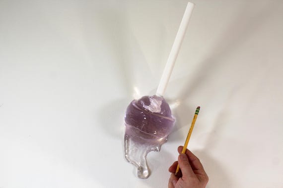 Giant wall blow pop lollypop tootsie pop melting down the wall light pink resin sculpture find out more.