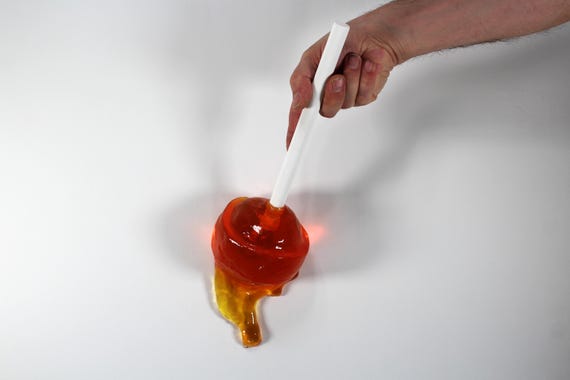 Giant wall blow pop lollypop tootsie pop melting down the wall citric orange resin sculpture find out more.