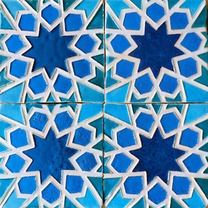 May include: Four blue and white ceramic tiles with a geometric pattern of stars and hexagons. The tiles are arranged in a square.