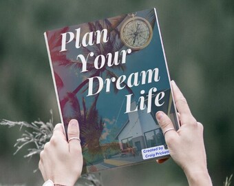 May include: A book titled "Plan Your Dream Life" with a compass on the cover and a tropical beach scene. The book is being held up by a person's hands.