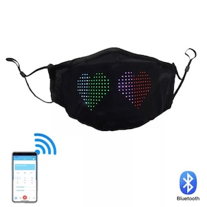 Op de afbeelding: Zwart gezichtsmasker met twee LED-hartontwerpen die in verschillende kleuren oplichten. Het masker is via Bluetooth verbonden met een smartphone. De tekst "Bluetooth" is zichtbaar in de afbeelding.
