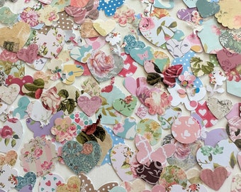 May include: Assortment of paper hearts in various floral patterns and colours, including pink, blue, green, and white. The hearts are cut from patterned paper and have a vintage aesthetic.