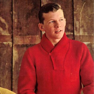 May include: A person wearing a bright red sweater with a shawl collar and a single button closure. The sweater is a solid color and appears to be made of a knitted material. The person is standing in front of a wooden background.