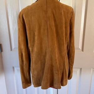 May include: A brown suede jacket with a collar and long sleeves.