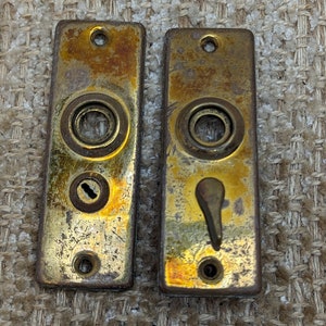 Peut inclure: Deux plaques de porte en laiton antique avec des trous de serrure et une petite poignée à levier. Les plaques sont usées et ont une finition patine.