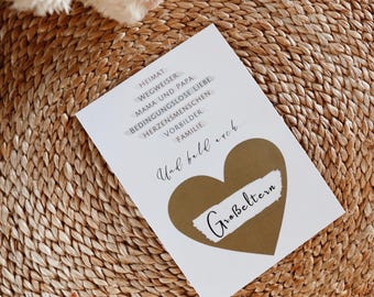Könnte beinhalten: Eine weiße Karte mit braunem Text, der lautet: "Heimat, Wegweiser, Mama und Papa, Bedingungslose Liebe, Herzensmenschen, Vorbilder, Familie, Und bald auch..." mit einer braunen Herzform mit dem Text "Großeltern" darauf.