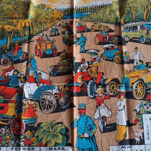 Puede incluir: Paño de cocina vintage de 1982 con una colorida ilustración de coches antiguos en una carretera. El diseño incluye un calendario con los meses en francés y una combinación de colores amarillo y marrón.