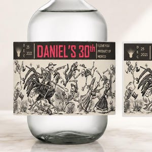 May include: A clear glass bottle with a cork stopper and a rectangular label featuring a black and white illustration of skeletons and a rooster. The label text reads DANIEL'S 30th, DEC 25 2021, and I LOVE YOU PRODUCT OF MEXICO.