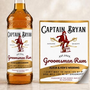 Könnte beinhalten: Eine Glasflasche mit bernsteinfarbenem Rum und einem individuellen Etikett mit Piratenillustration, gekreuzten Säbeln und dem Text Captain Bryan Groomsman Rum, Alicia & Ken's Wedding, Est. 2025. Ein passendes rechteckiges Aufkleber-Etikett liegt daneben.