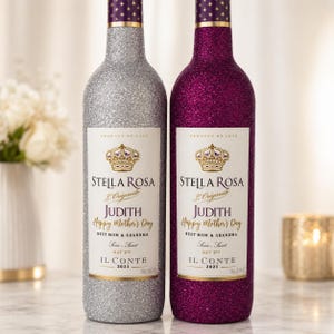 May include: Two wine bottles with glitter coatings, one silver and one magenta. Each label features a crown icon, the text Stella Rosa L'Originale, the name Judith, Happy Mother's Day, Best Mom & Grandma, May 9th, Il Conte 2021, and 750ml 25.4 fl oz.
