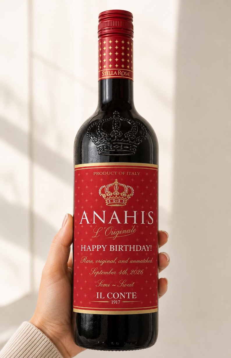 May include: A dark glass wine bottle with a red label featuring a gold crown icon and the text ANAHIS L'Originale, HAPPY BIRTHDAY!, Rare, original, and unmatched, September 4th, 2026, Semi-Sweet, IL CONTE 1917, and Stella Rosa on the red screw cap.