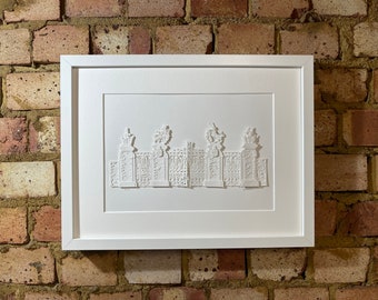 May include: A white framed paper art piece depicting a detailed, three-dimensional, paper-cut design of a gate with ornate details.