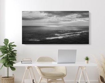 May include: A black and white photograph of a seascape with dramatic clouds and a calm ocean.