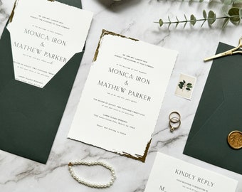 May include: Wedding invitation suite featuring a white invitation with gold trim and dark green envelopes. The invitation includes the names Monica Iron & Mathew Parker. Additional elements include a pearl bracelet, rings, and a wax seal.