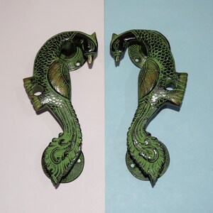 May include: Two ornate green peacock door handles with intricate details. The handles are made of brass and have a traditional Indian design.