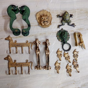 May include: A collection of brass hardware including two green-patina bird-shaped handles, a mask, a frog, two horse-shaped wall hooks, two vertical horse handles, a circular door knocker, a long latch, and six small fish-shaped wall hooks.