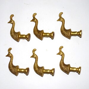 Puede incluir: Seis pomos de puerta de color dorado en forma de pavo real con un acabado texturizado. Cada pomo tiene una base redonda y un agujero para tornillo.
