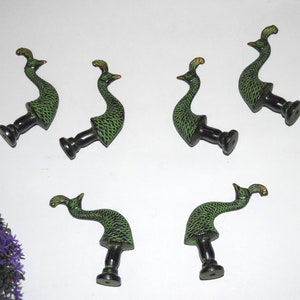 May include: Six green and gold peacock-shaped drawer pulls with black bases.