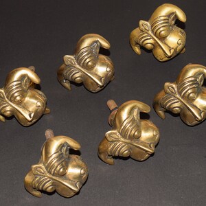 May include: Six gold-toned metal cabinet knobs with a detailed animal design. Each knob has a screw on the back for installation.