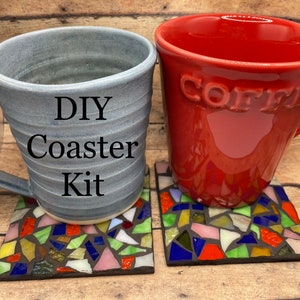 May include: DIY Coaster Kit with two mugs, one gray and one red, sitting on top of two colorful mosaic coasters.