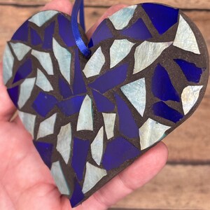 May include: A blue and white mosaic heart ornament with a blue string for hanging.