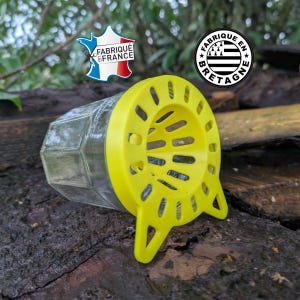 Peut inclure: Un bocal en verre transparent avec un couvercle en plastique jaune vif doté d'une ouverture en forme d'entonnoir et de deux petits pieds. Le couvercle porte les inscriptions FABRIQUÉ EN FRANCE et FABRIQUÉ EN BRETAGNE. Posé horizontalement.