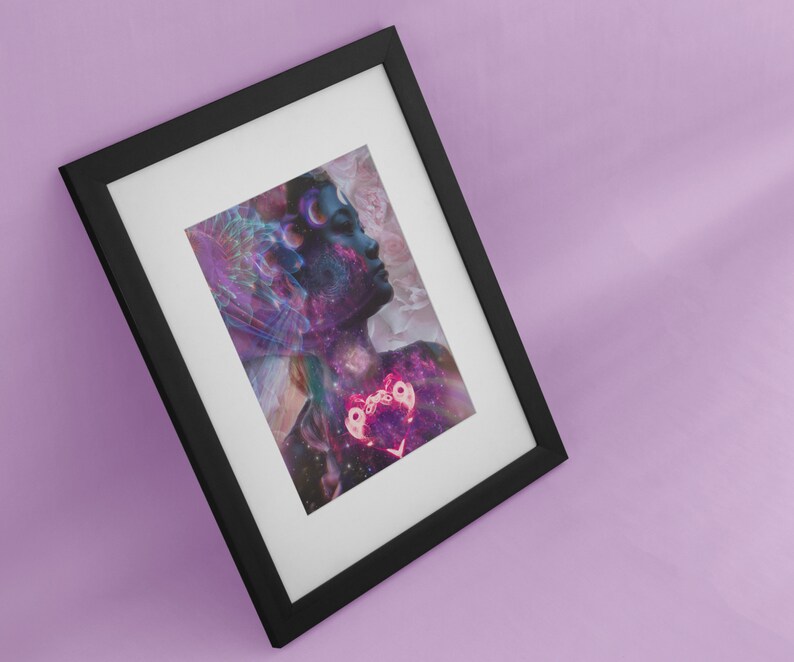 Op de afbeelding: Een ingelijste print van een vrouwen gezicht met een galaxie achtergrond en een roze hart in het midden. Het gezicht van de vrouw is gedeeltelijk bedekt door een draaiende galaxie van kleuren.