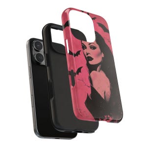 May include: A black smartphone with a black case and a pink case featuring a vintage illustration of a woman with bats. The pink case has a glossy finish and a cutout for the camera.