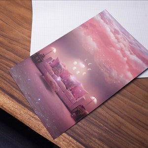 May include: A pink and white couch with pillows sits in a room with a pink and white cloudy sky background. The couch is surrounded by white lights and there are white crescent moons in the sky.