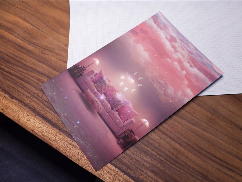 May include: A pink and white couch with pillows sits in a room with a pink and white cloudy sky background. The couch is surrounded by white lights and there are white crescent moons in the sky.