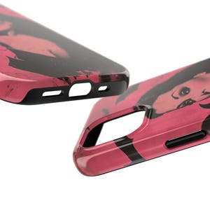 May include: Two phone cases with a pink and black abstract design. The cases have a glossy finish and a black border. The design appears to be a stylized portrait. The cases are shown at an angle, highlighting the details of the design and the phone's features.