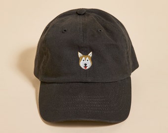 May include: A black baseball cap with a small embroidered image of a dog's face on the front.