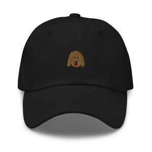 May include: Black baseball cap with an embroidered brown dog face on the front.