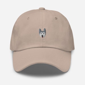 May include: A beige dad hat with an embroidered husky dog face on the front.
