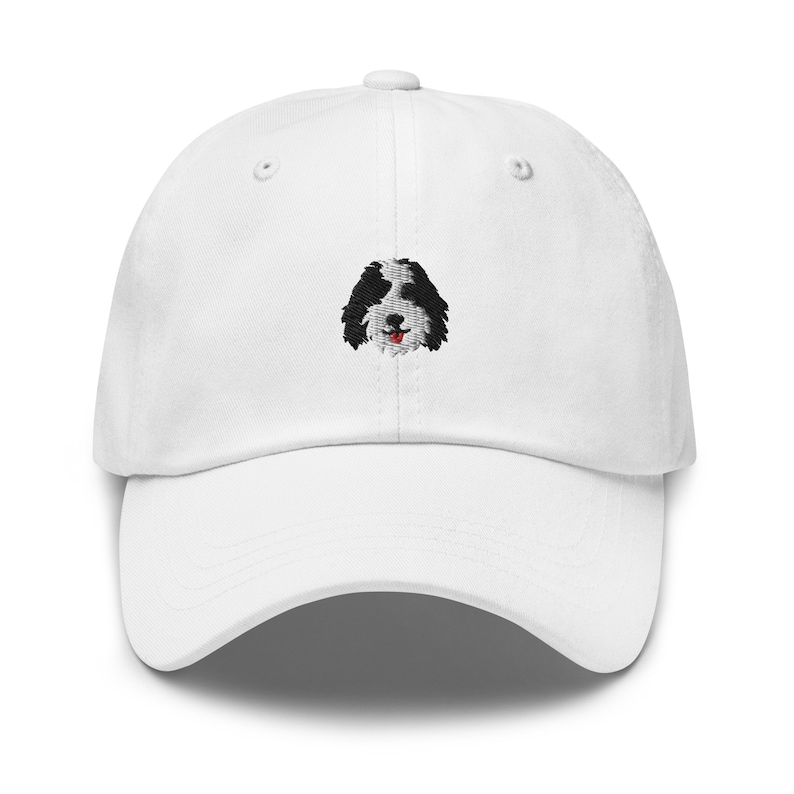 K&ouml;nnte beinhalten: Wei&szlig;e Baseballkappe mit einem gestickten schwarzen und wei&szlig;en Hundefoto.
