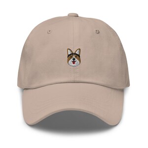 May include: A beige dad hat with an embroidered image of a corgi dog.