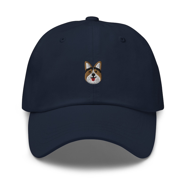 May include: A navy blue baseball cap with an embroidered image of a corgi wearing sunglasses.