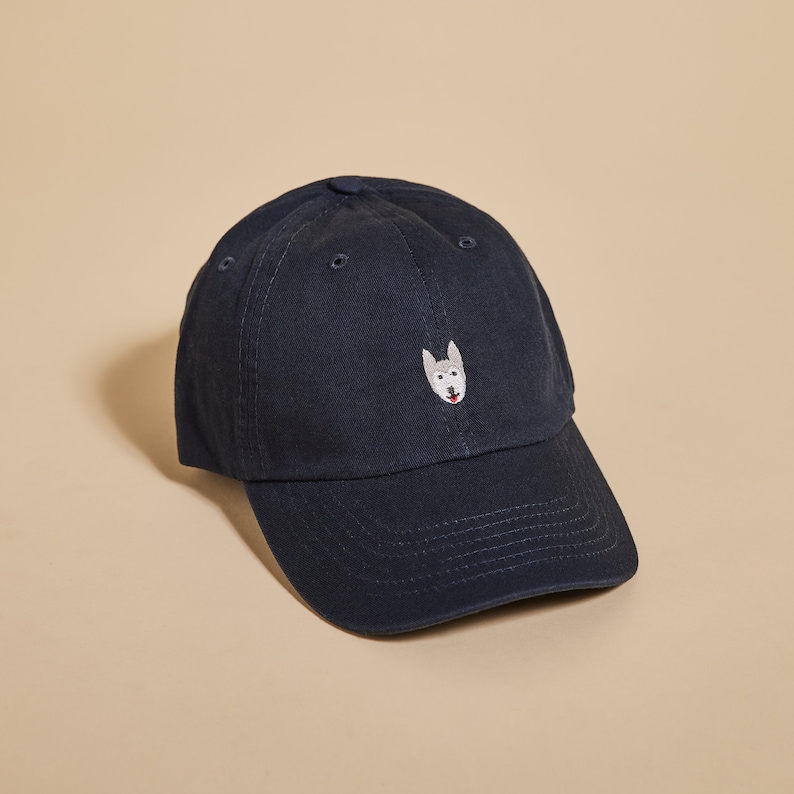 May include: A dark blue baseball cap with an embroidered white husky face on the front.