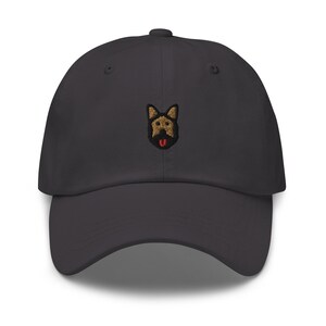May include: A dark gray baseball cap with an embroidered German Shepherd dog face on the front.