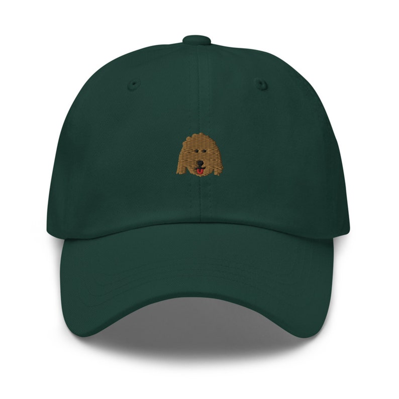 May include: A dark green baseball cap with an embroidered brown dog face on the front.