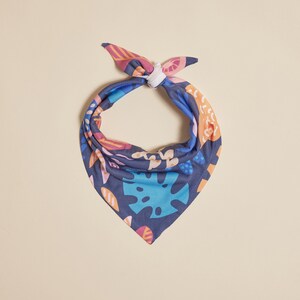 May include: A blue bandana with a colorful floral and leaf pattern. The bandana is tied in a knot at the top.