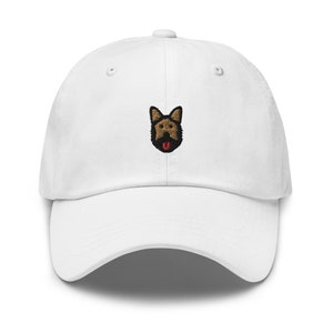 May include: White baseball cap with an embroidered brown and black German Shepherd dog face with a red tongue.