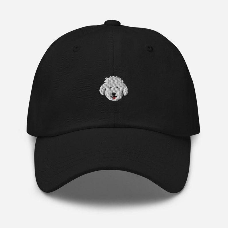 May include: Black baseball cap with an embroidered white poodle face.