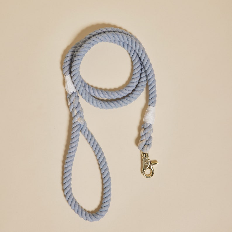 May include: A light blue cotton rope dog leash with a gold metal clip.