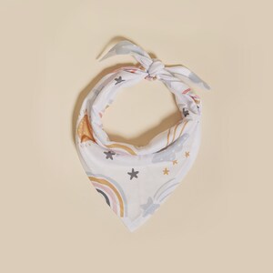 May include: White bandana with a colorful rainbow, stars, and clouds pattern.