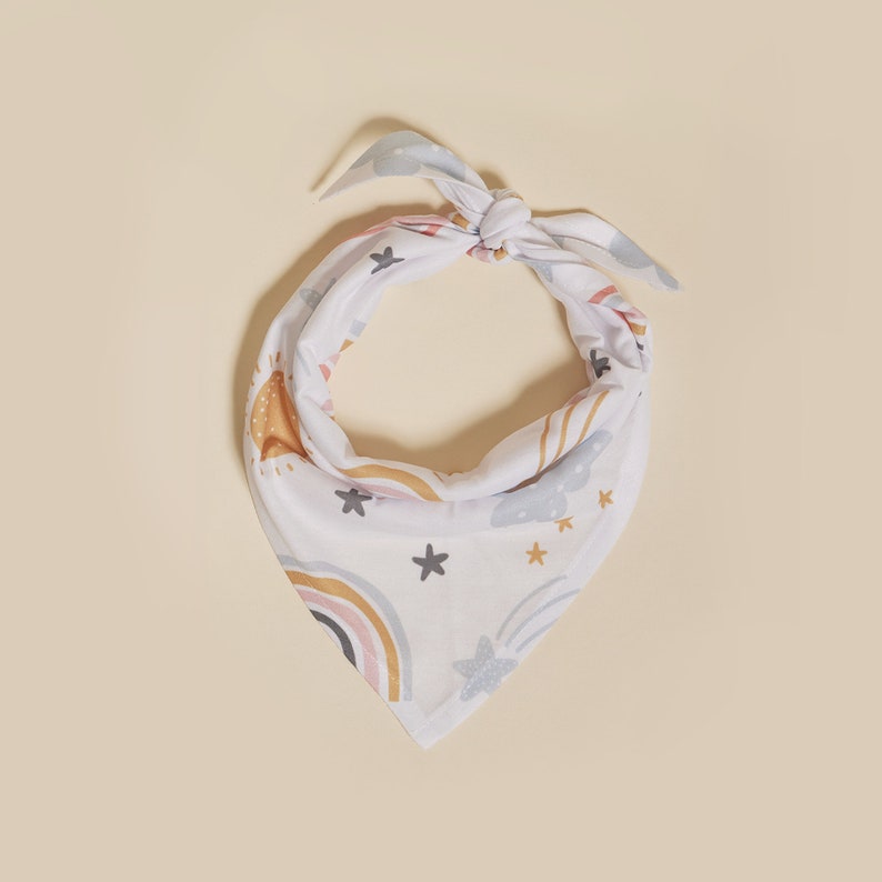 May include: White bandana with a colorful rainbow, stars, and clouds pattern.