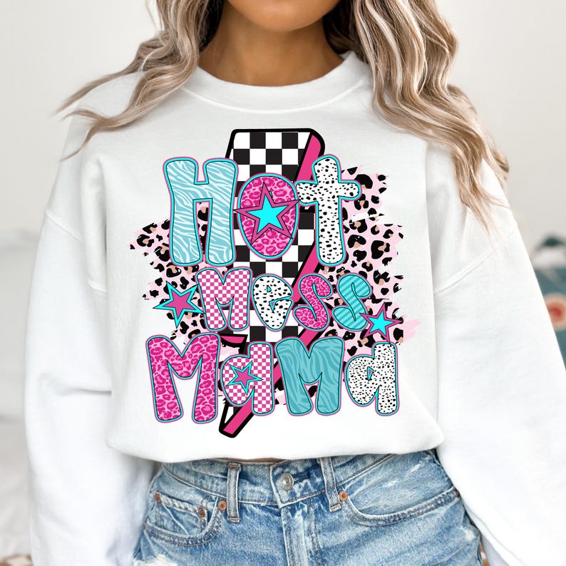 May include: White sweatshirt with a graphic design of a lightning bolt with the text "Hot Mess Mama" in pink, blue, and black with a checkered pattern and animal print.