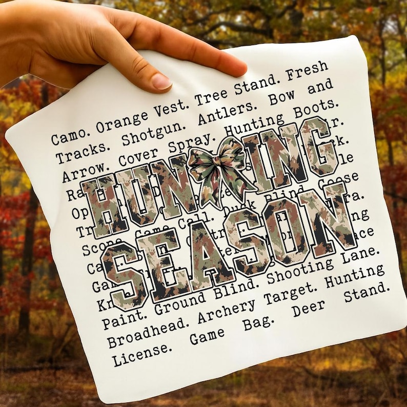 May include: A white pillow with the words "HUNTING SEASON" in large, camouflage-patterned letters. The pillow also features a camouflage bow and a list of hunting-related terms in black text.