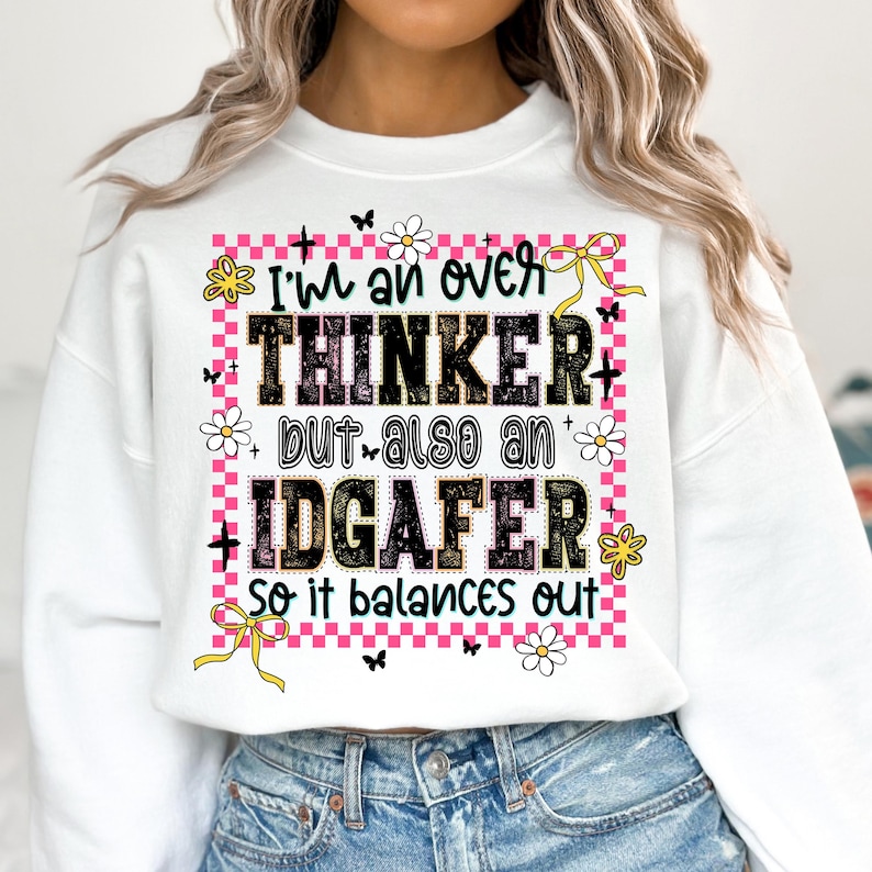 May include: White sweatshirt with the text "I'm an over THINKER but also an IDGAFER so it balances out." The text is in black, with a pink checkered border, flowers, butterflies, and yellow bows.