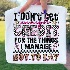 May include: White sweatshirt featuring the phrase "I don't get enough credit for the things I manage not to say." The text uses various fonts and colours, including pink, black, and leopard print.